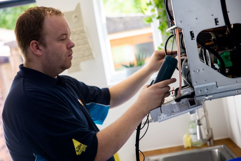 Newcastle heating technician repairing a boiler at night, ensuring warmth during frosty winter nights