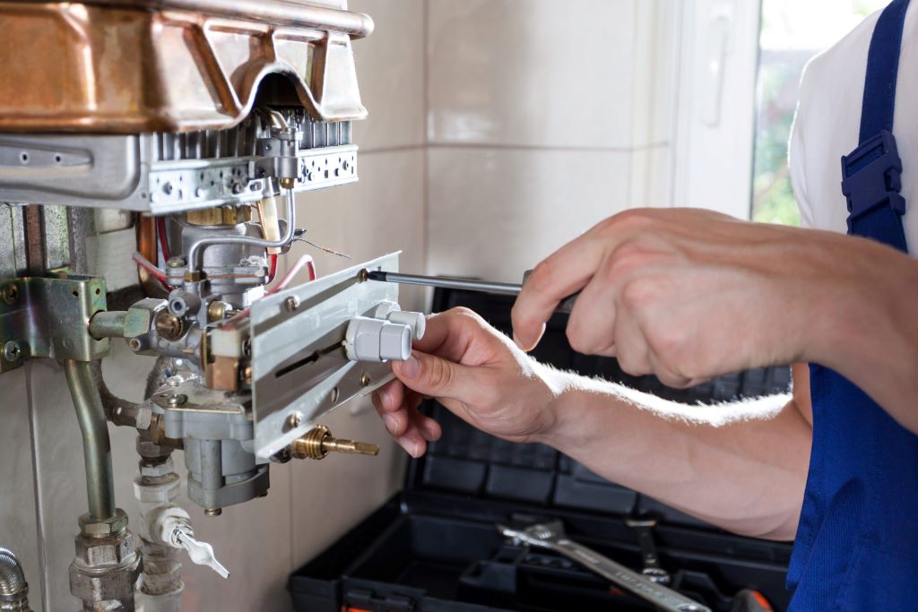 Newcastle heating technician repairing a boiler at night, providing 24/7 emergency service during frosty winter conditions