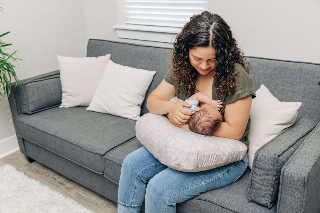 Mother breastfeeding comfortably with an ergonomic nursing pillow