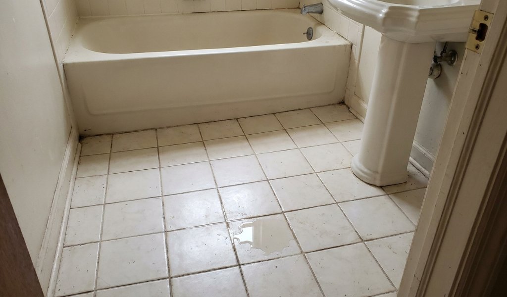 Self leveling underlayment being applied to a bathroom subfloor
